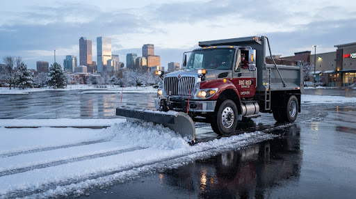 Commercial snow removal clearing a property in Denver at dawn